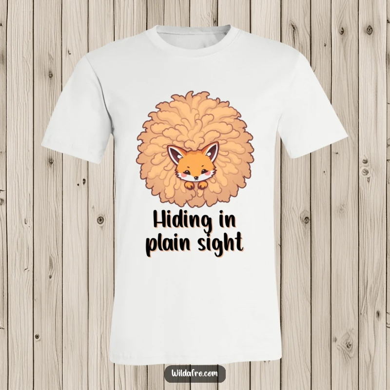 Funny t-shirt featuring a cunning fox peeking from a massive, curly afro, embodying playful mischief and intrigue.